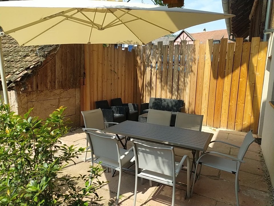 La terrasse du gîte Le 67, table et parasol au calme de la cour